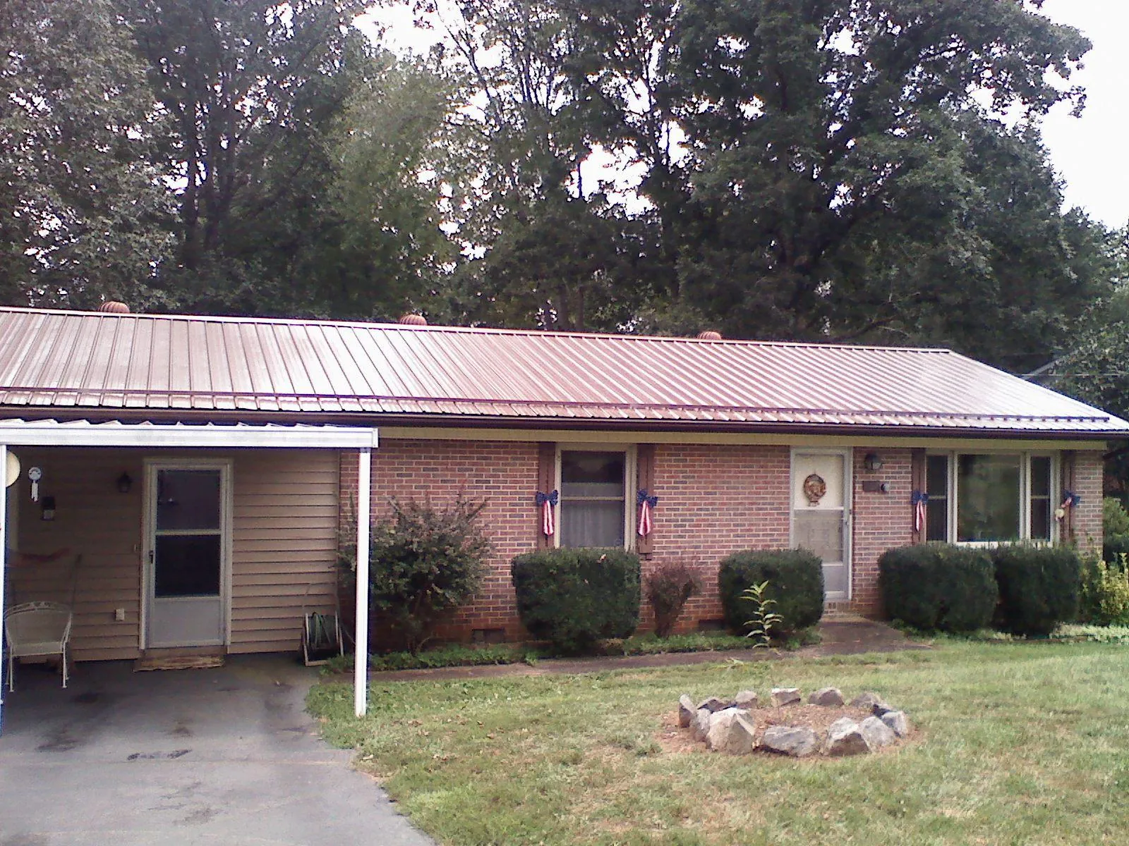Bronze metal roof and carport on a brick ranch home — Roof Repair work by our crew in Savage